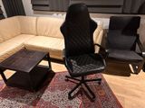 a black office chair sitting on a rug in a living room