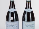 deux bouteilles de vin posées l'une à côté de l'autre sur une surface blanche