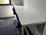 a desk with a chair and a window in the room