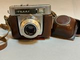 a brown camera with a leather case and a brown strap