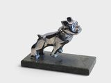 statue d'un chien coiffé d'un haut-de-forme, posée sur un socle en marbre