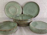 four bowls and two plates sitting on a table