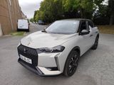 une voiture blanche garée dans un parking à côté d'un bâtiment
