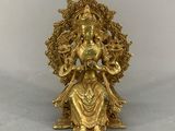 a gold statue of a woman sitting on top of a table
