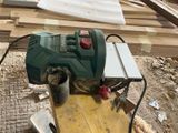 a green machine that is sitting on top of a wooden table