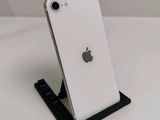 a white iphone on a black stand on a white table