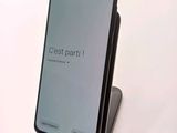 a close up of a cell phone on a stand on a white surface