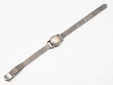 un gros plan d'une montre sur une surface blanche avec un fond blanc