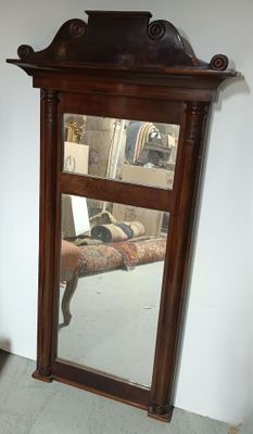 un miroir accroché au mur à côté d'une chaise