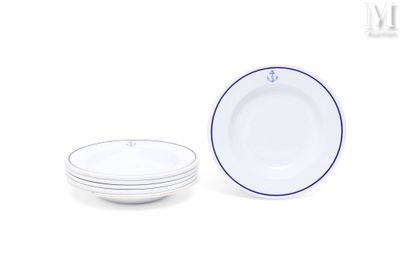 une assiette blanche à bord bleu, à côté d'une pile d'assiettes blanches