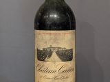 une bouteille de vin posée sur un tonneau en bois