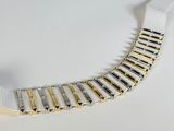 a close up of a white and gold bracelet on a white surface