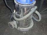 a vacuum that is sitting on the floor next to a chair
