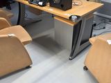several chairs and a desk with a computer on it in a room