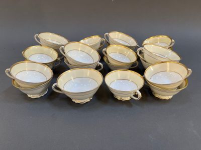 six cups and saucers with gold rims on a black surface