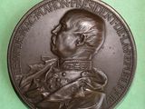 an old bronze medal of a man with a dog on it