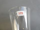 un vase transparent sur lequel est collé un autocollant rouge