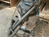 un aspirateur posé par terre devant une armoire
