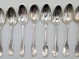 six spoons are lined up in a row on a white surface