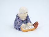 a figurine of a man reading a book