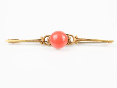 Broche barrette en or, centrée d'un cabochon de corail. Tige…