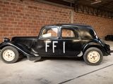 a black car parked in front of a brick wall