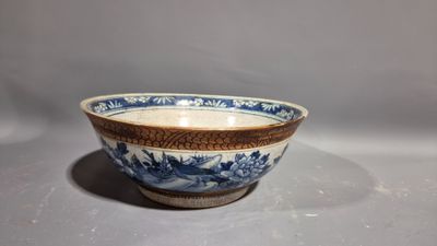 an old blue and white bowl sitting on top of a table