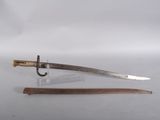an old sword with a wooden handle sitting on top of a white surface