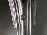 a close up of a silver metal table with a wooden top
