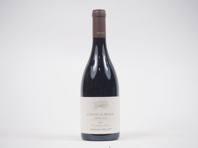 une bouteille de vin rouge posée sur une table blanche