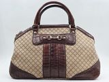 un sac à main marron et beige muni d'une poignée marron