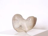une sculpture en marbre posée sur un socle blanc, elle-même posé sur une surface blanche