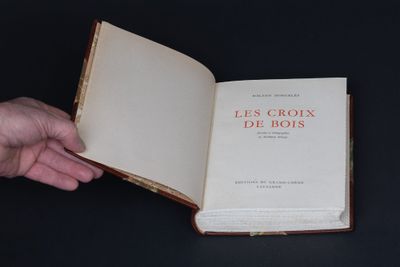 une personne tenant un livre ouvert sur une table