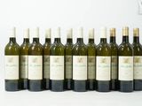 six bouteilles de vin sont alignées sur une surface blanche
