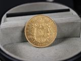 une pièce d'or posée dans un écrin sur une table