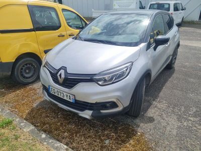 une voiture argentée garée sur un parking à côté d'une camionnette jaune