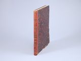 an old book sitting on top of a white surface