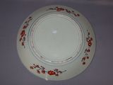 a white plate with red flowers on it on a table