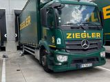 a green truck that is parked in a lot