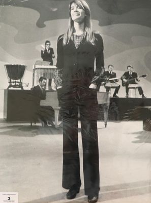 photographie en noir et blanc d'une femme debout devant un groupe de musique