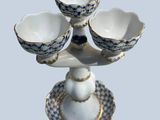 four bowls on a stand with a blue and white checkered pattern