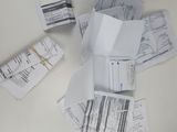a pile of papers on the table next to a pair of scissors