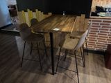 une table en bois entourée de quatre chaises dans une pièce