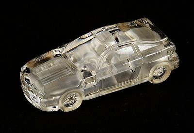 a clear toy car that is sitting on a black surface