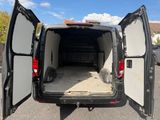 une camionnette noire dont les portes sont ouvertes, garée sur un parking