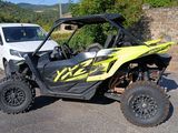 a yellow and black utv parked next to a white truck