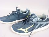une paire de chaussures de tennis bleues avec des touches de jaune sur un fond blanc