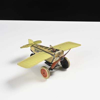 un avion jouet posé sur une surface blanche