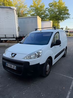 La camionnette blanche est garée sur le parking, à côté du camion.
