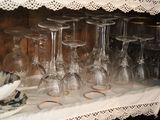many wine glasses sitting on a shelf next to a plate